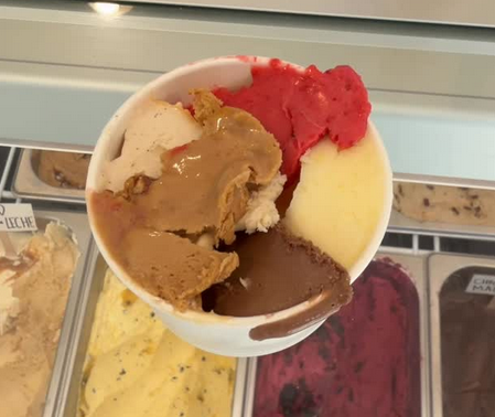 Mixed gelato cup over the flavour cabinet