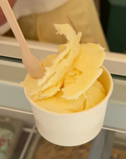 Yellow pineapple sorbet in a white cup